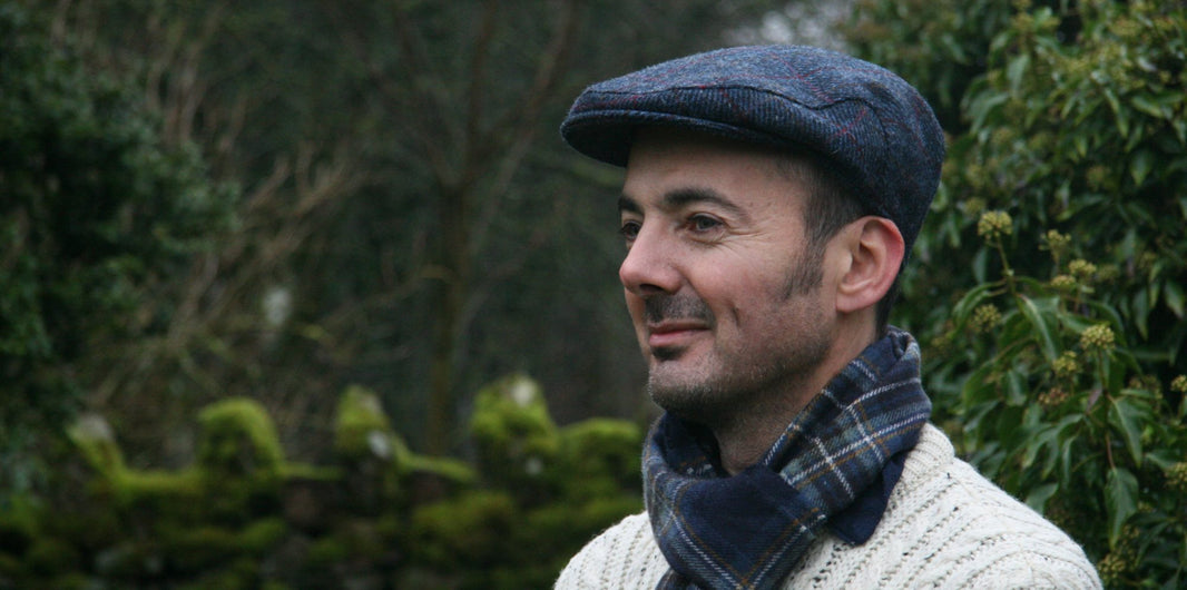 Man wearing Harris Tweed flat cap, lambswool scarf and Aran Jumper