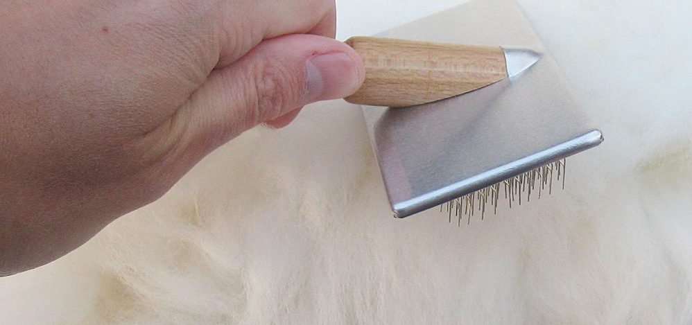 Hand holding sheepskin brush