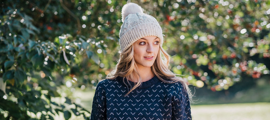 female wearing saxon jumper and sheepskin bobble hat