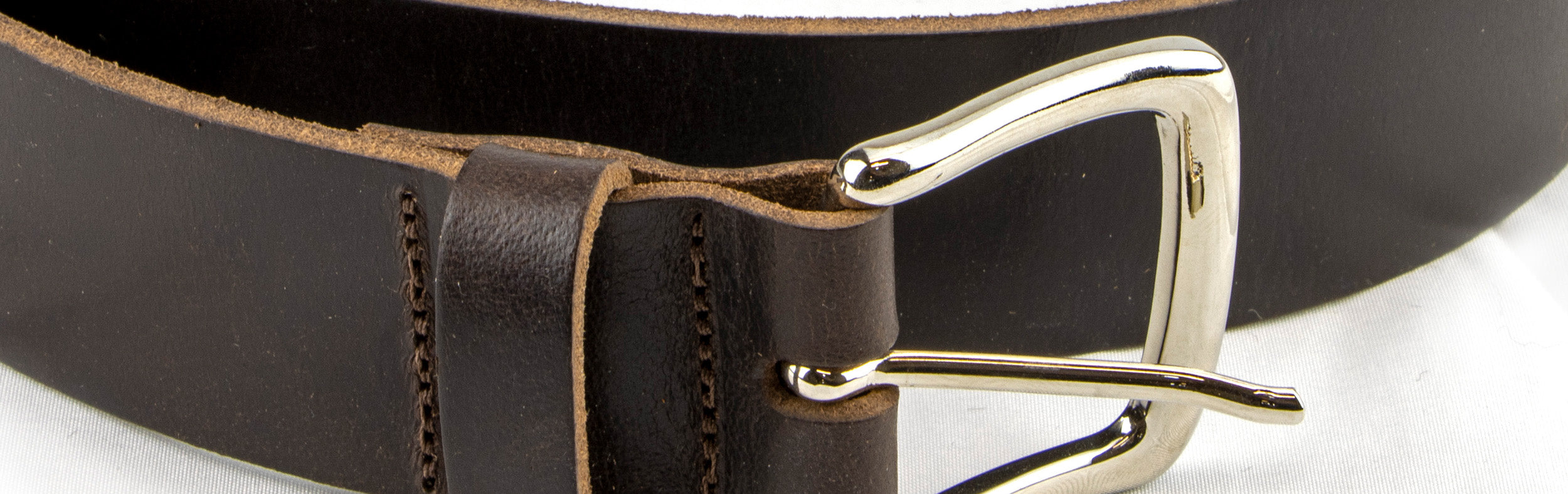 Close up of a brown leather belt and silver buckle