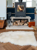 White sheepskin rug in front of fireplace 