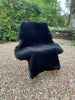 Black short haired sheepskin rug on chair