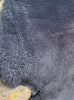 Close up of black short haired sheepskin rug 