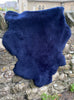 Navy short haired sheepskin rug on wall 