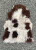 Brown and grey sheepskin rug on gravel