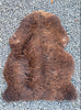 Dark brown sheepskin rug laid flat