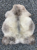 Grey sheepskin rug laid flat