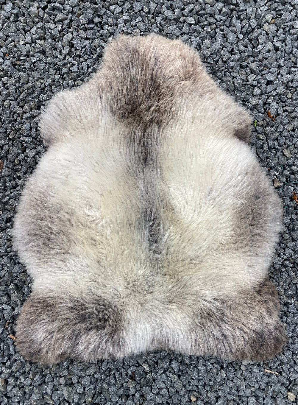 Grey sheepskin rug laid flat