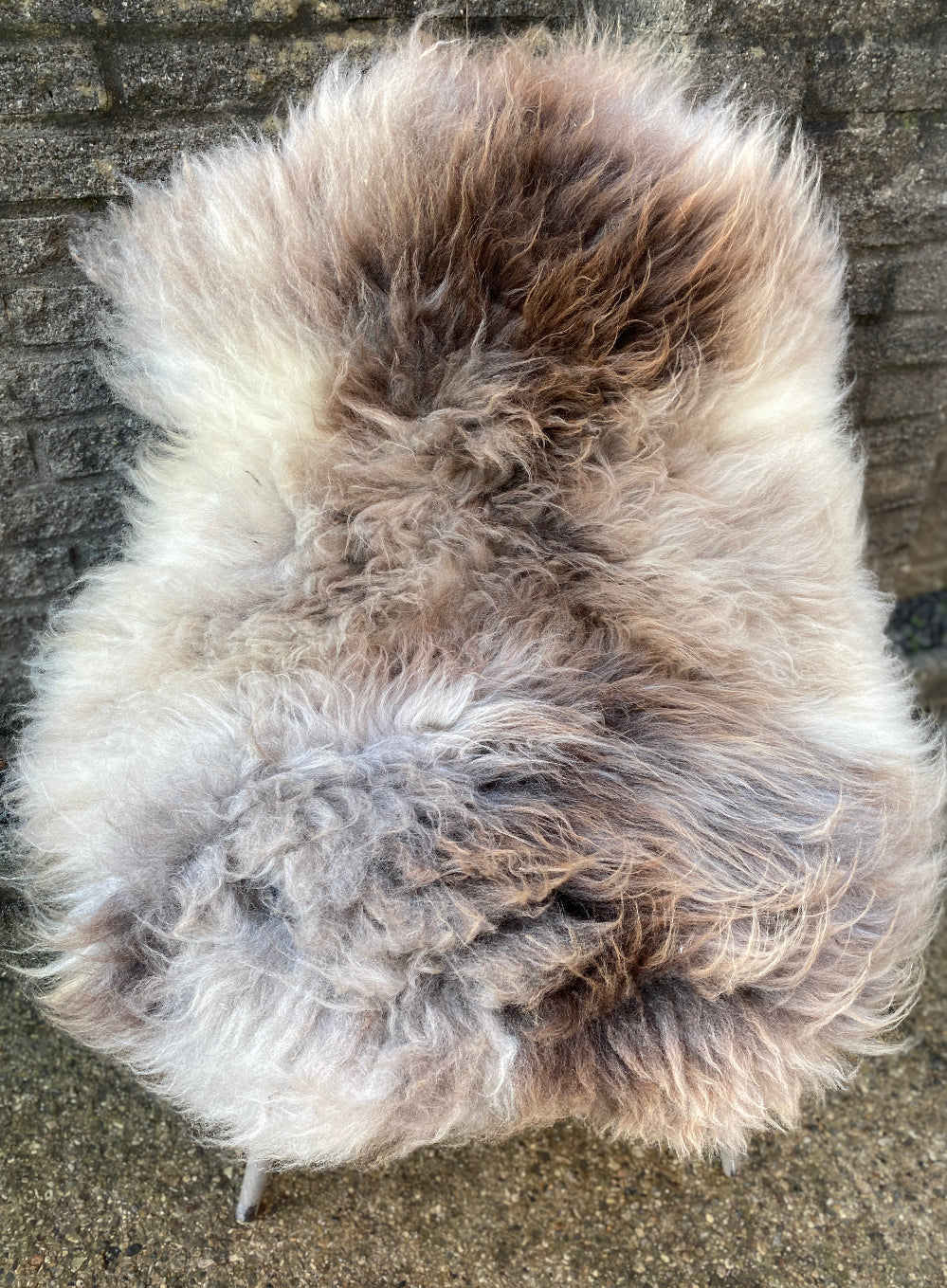 brown, cream and grey sheepskin rug on chair