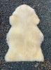 Cream sheepskin rug laid flat