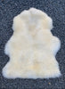 cream sheepskin rug on gravel 