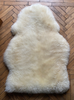Cream sheepskin rug laid flat