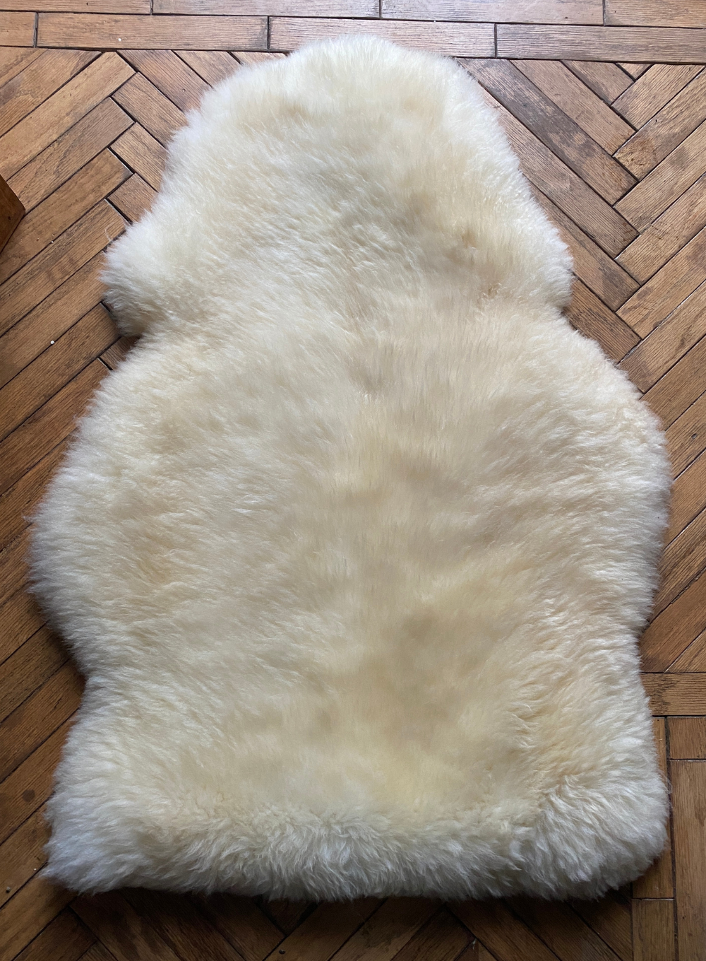 Cream sheepskin rug laid flat