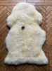 Cream sheepskin rug laid flat