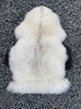 Cream sheepskin rug laid flat