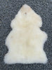 Cream sheepskin rug laid flat