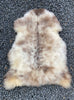 Cream and brown speckled sheepskin rug laid flat