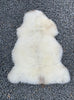 Cream sheepskin rug laid flat