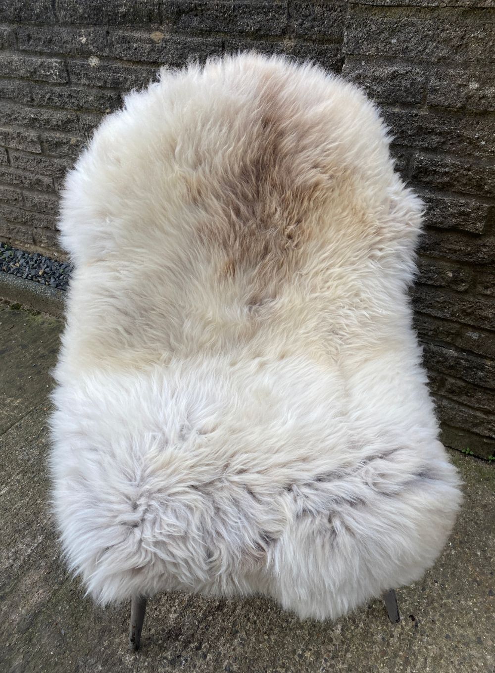 Cream speckled sheepskin rug on chair