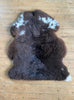 Brown sheepskin rug with cream spots laid flat