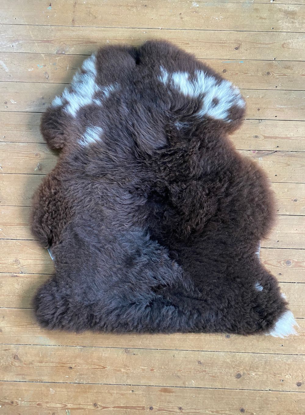 Brown sheepskin rug with cream spots laid flat