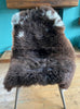 Brown sheepskin rug with cream spots on chair