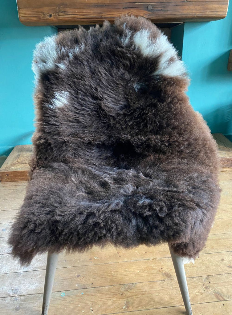 Brown sheepskin rug with cream spots on chair