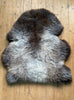 Brown and grey sheepskin rug laid flat 