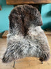 Brown and grey sheepskin rug on chair 
