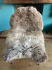 Brown and cream sheepskin rug on chair 
