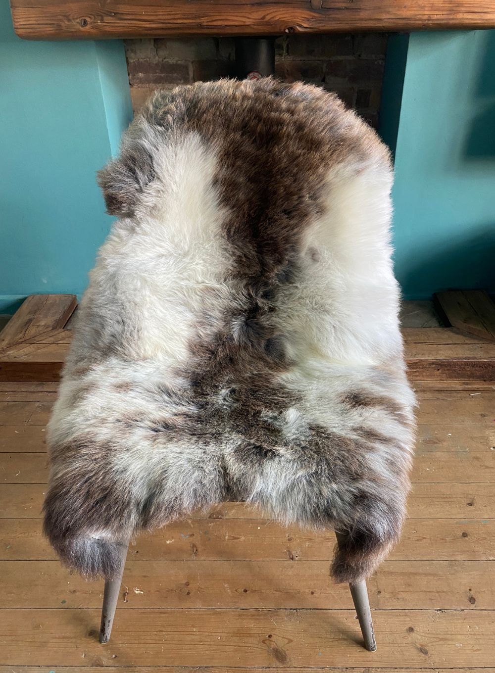 Brown and cream speckled sheepskin rug on chair