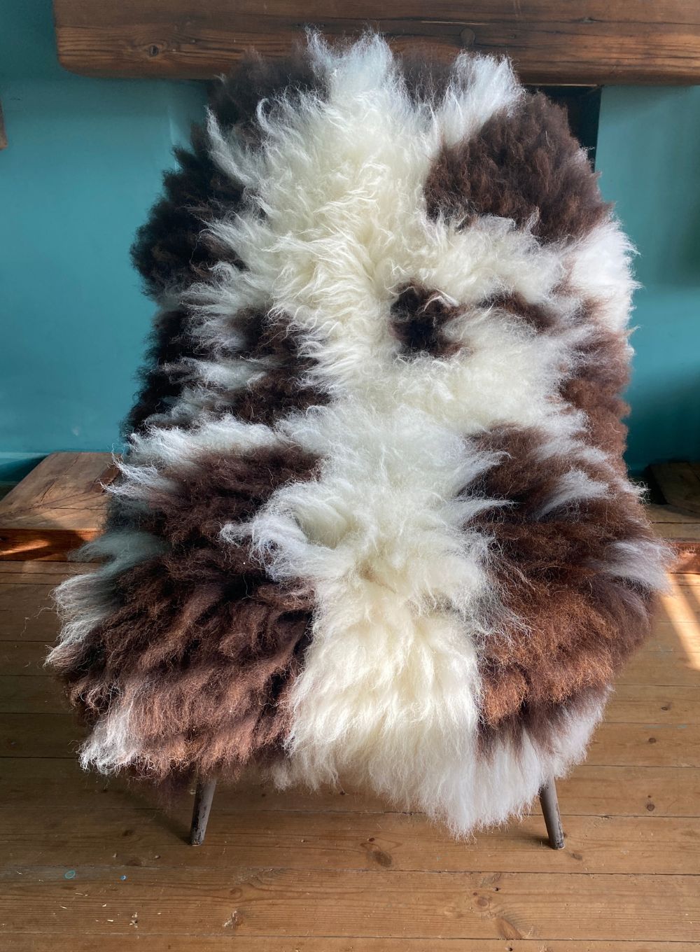 Cream and brown spotty sheepskin rug on chair