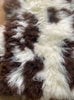 Cream and brown spotty sheepskin rug close up 