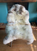 Cream speckled sheepskin rug on chair