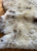 Cream speckled sheepskin rug close up