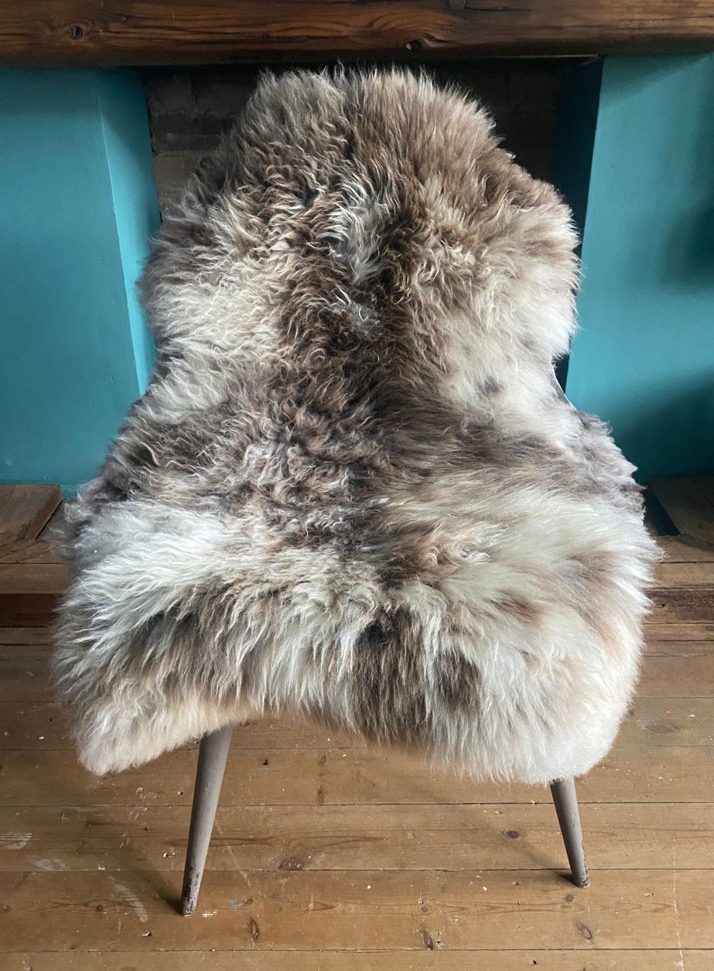 Cream and brown speckled sheepskin rug on chair