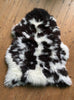 Brown and cream spotty sheepskin laid flat on wooden floor