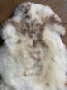 Cream speckled sheepskin rug close up