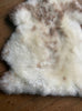 Cream speckled sheepskin rug close up
