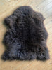 Brown sheepskin rug on wooden floor