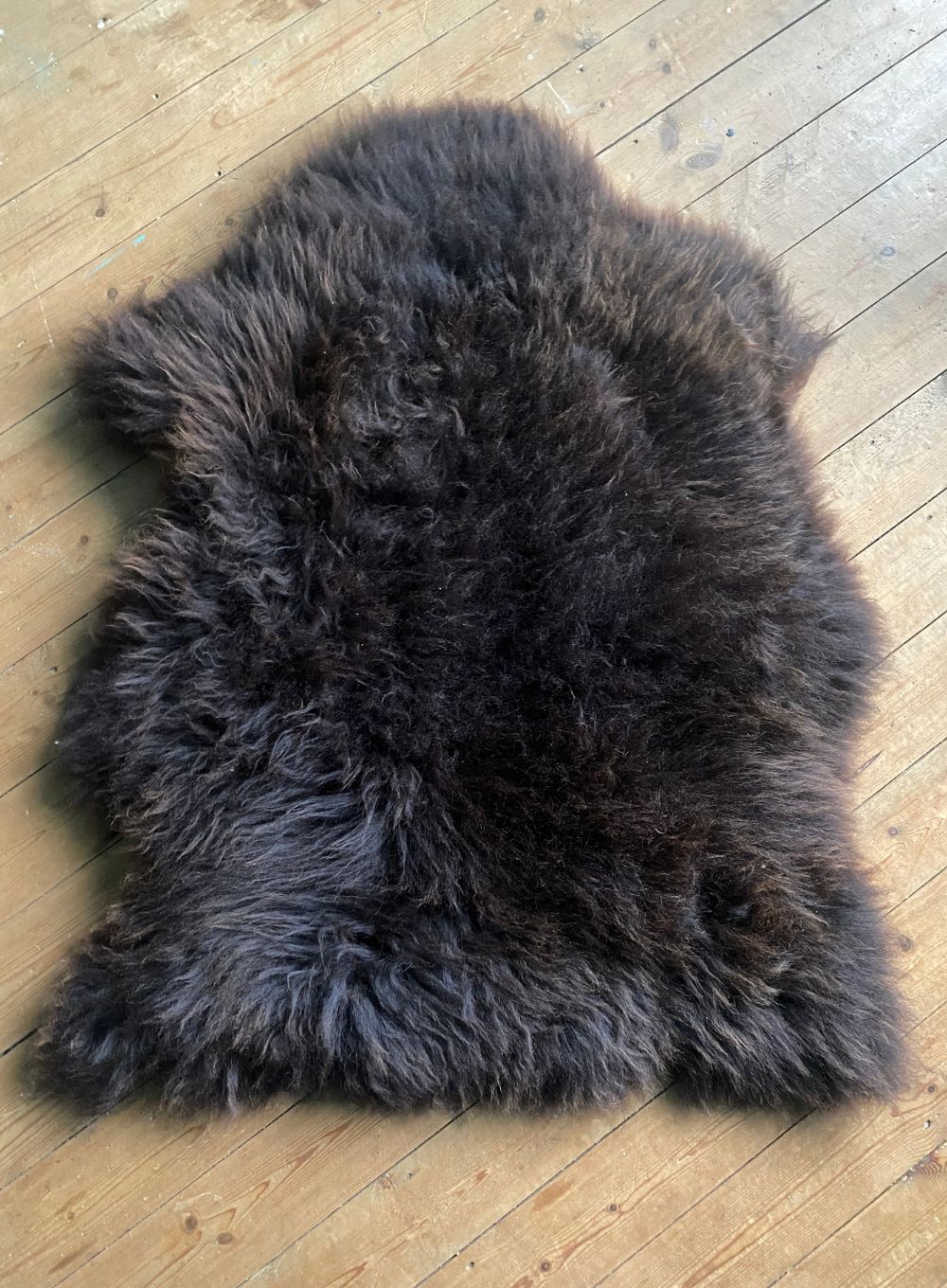 Brown sheepskin rug on wooden floor
