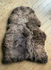 Brown sheepskin rug on wooden floor 