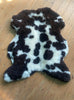 Brown and cream sheepskin rug on wooden floor 