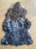 Brown sheepskin rug on wooden floor
