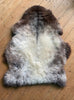 Brown and grey sheepskin rug on wooden floor