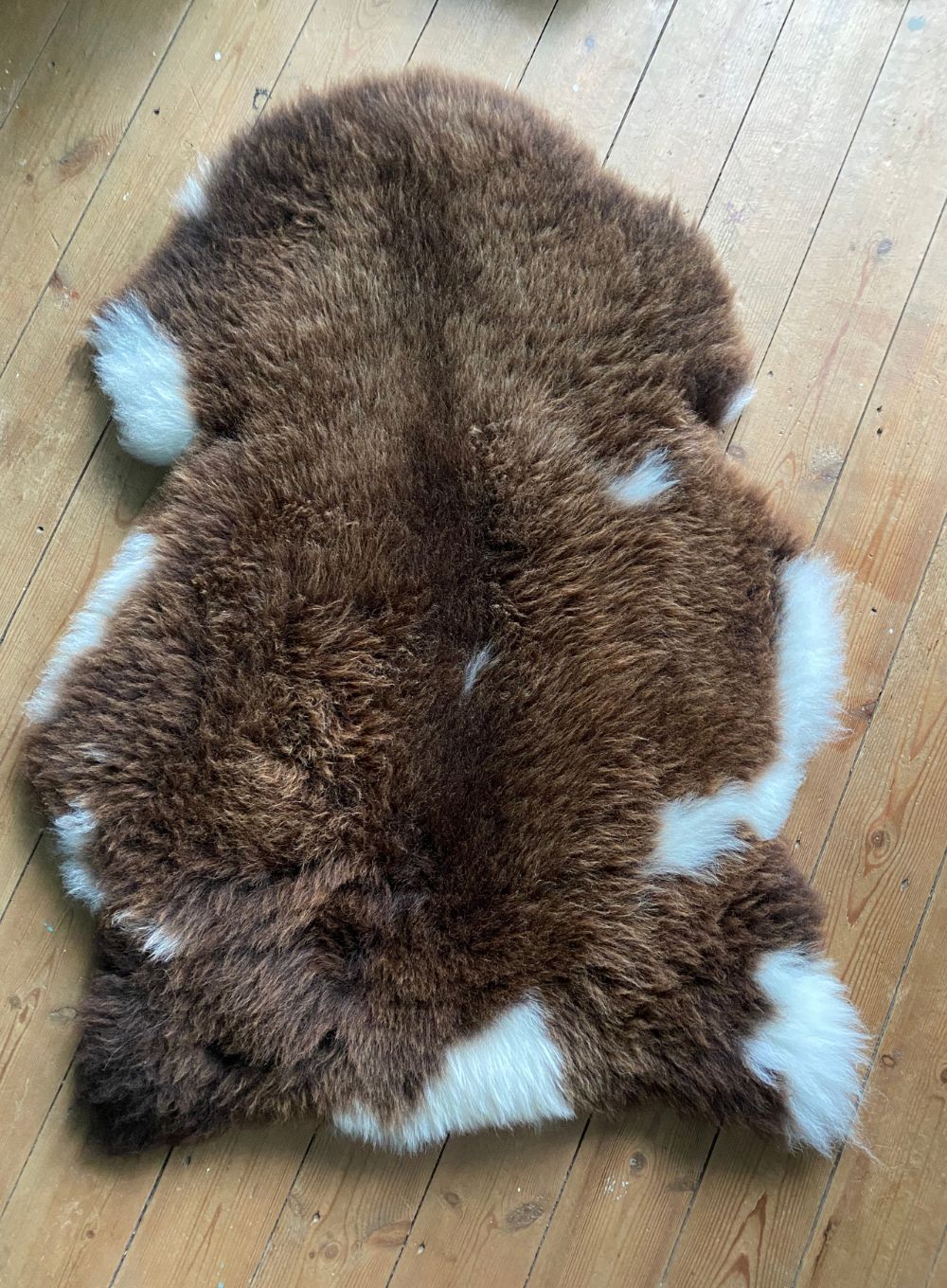 Brown and cream sheepskin rug laid flat 