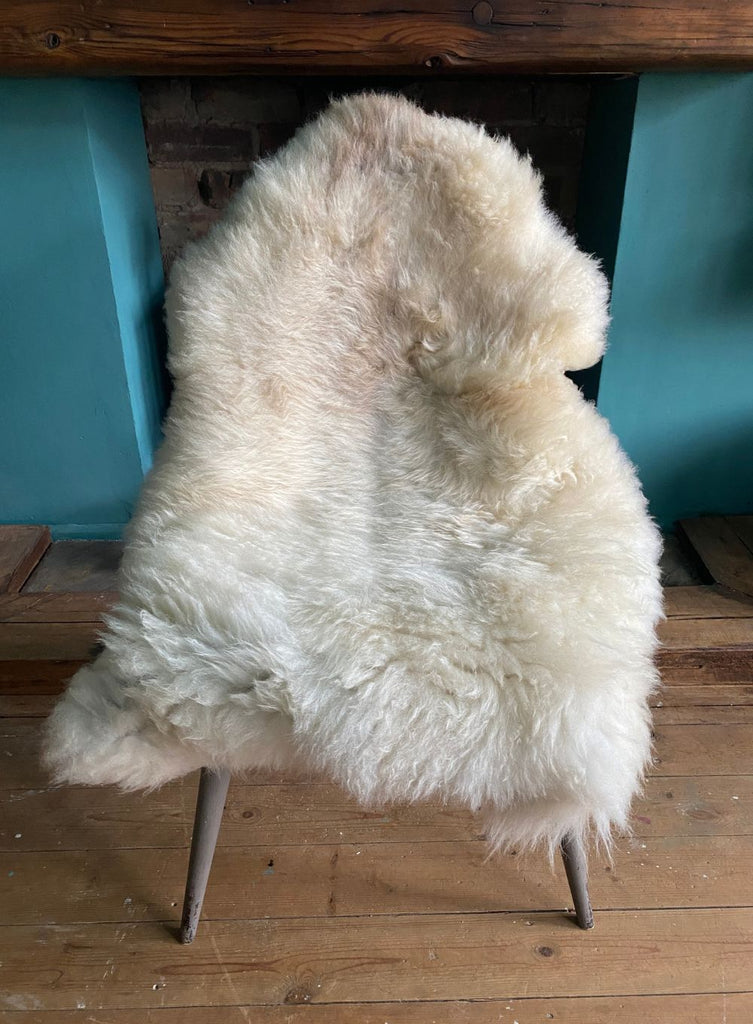 Cream speckled sheepskin rug on chair