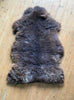 Brown sheepskin rug on wooden floor