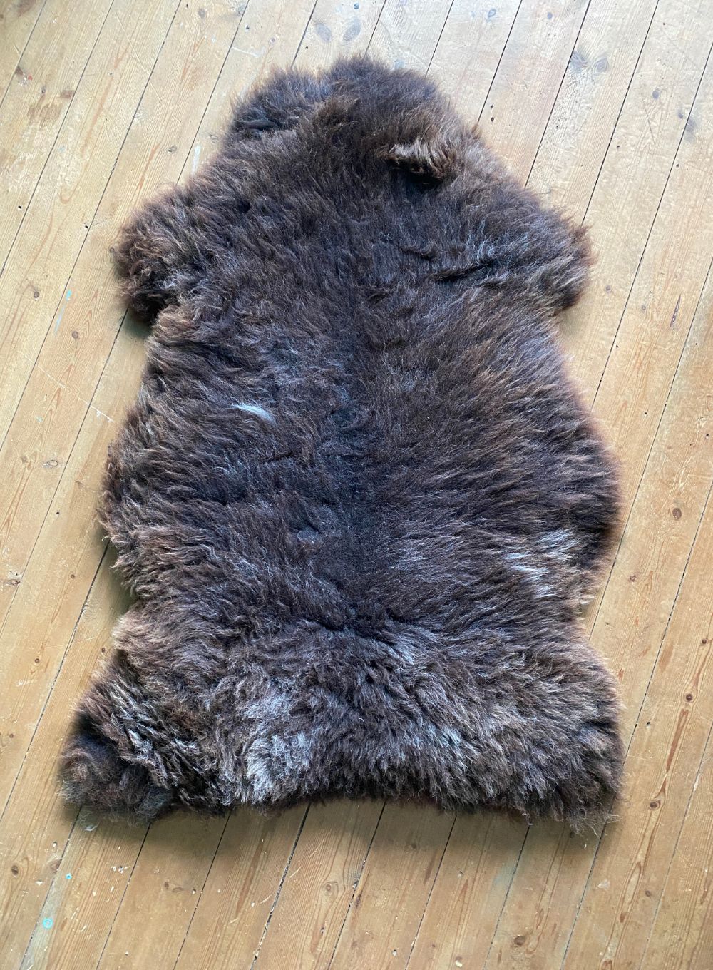 Brown sheepskin rug on wooden floor