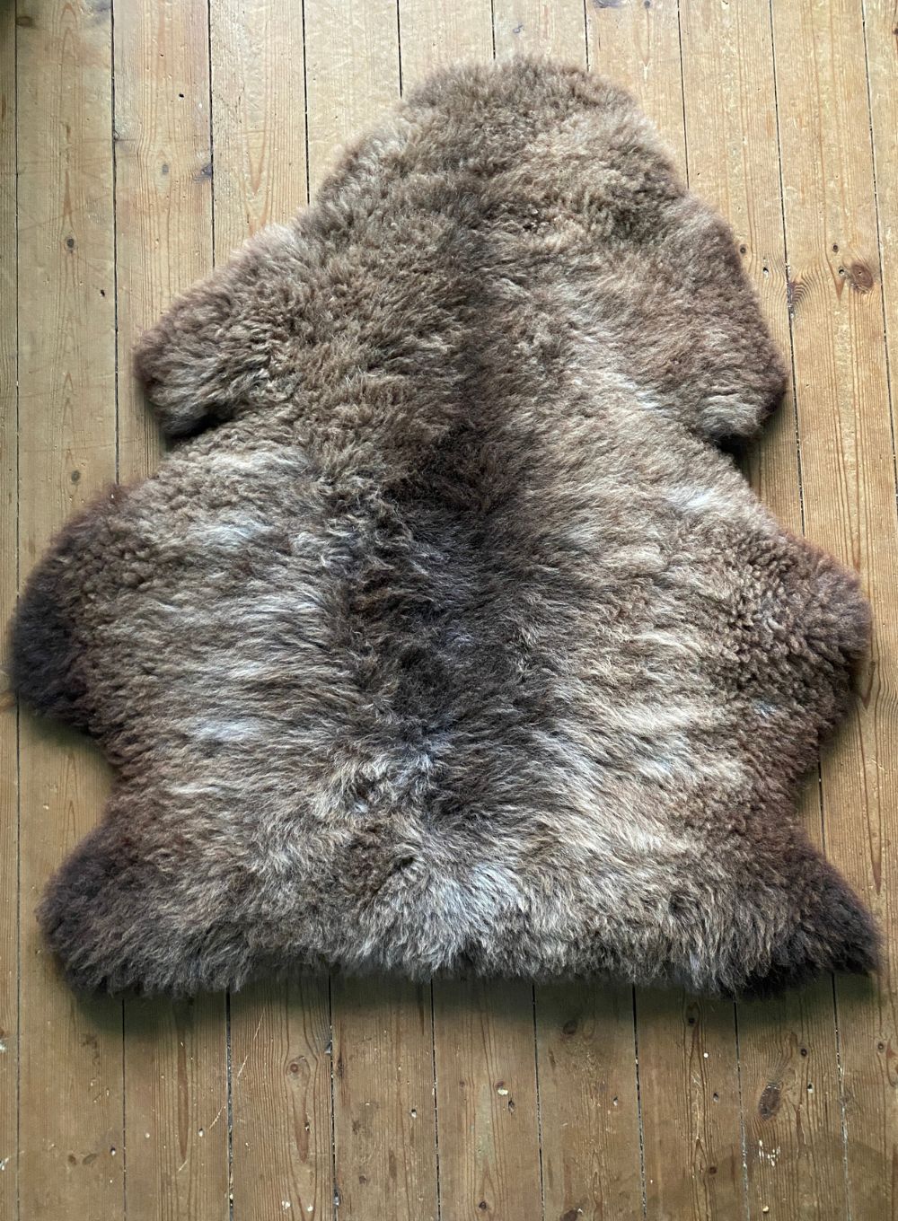 Brown sheepskin rug on wooden floor